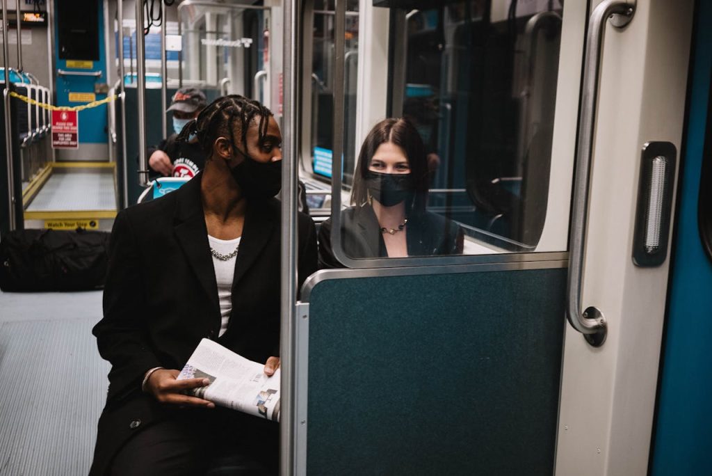 The Art of Drawing Readers In: Your attractive post title goes here Two masked individuals observed on a train demonstrating new normal travel practices during COVID-19.