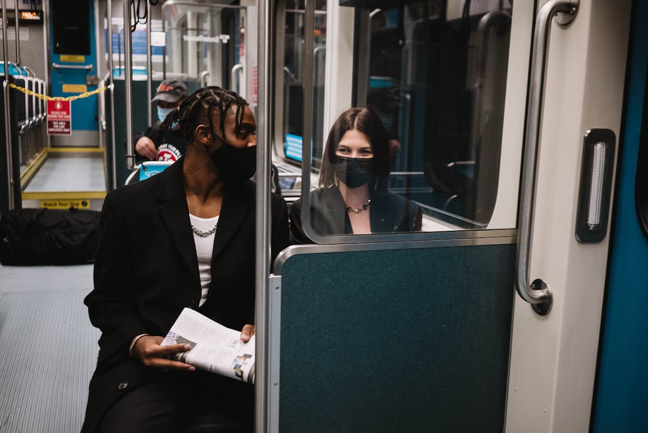 The Art of Drawing Readers In: Your attractive post title goes here Two masked individuals observed on a train demonstrating new normal travel practices during COVID-19.
